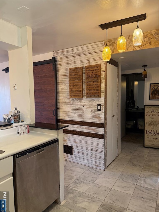 kitchen featuring marble finish floor, decorative light fixtures, light countertops, a barn door, and dishwasher