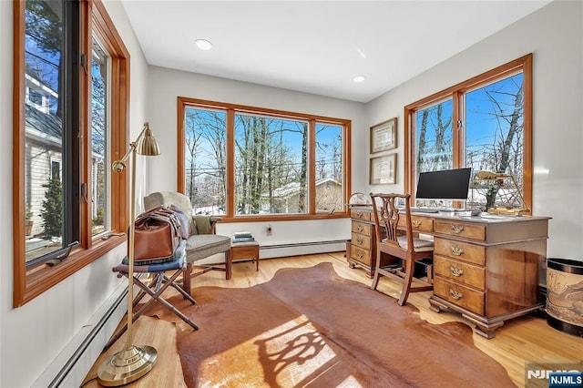 office space with light wood finished floors, a baseboard heating unit, and recessed lighting