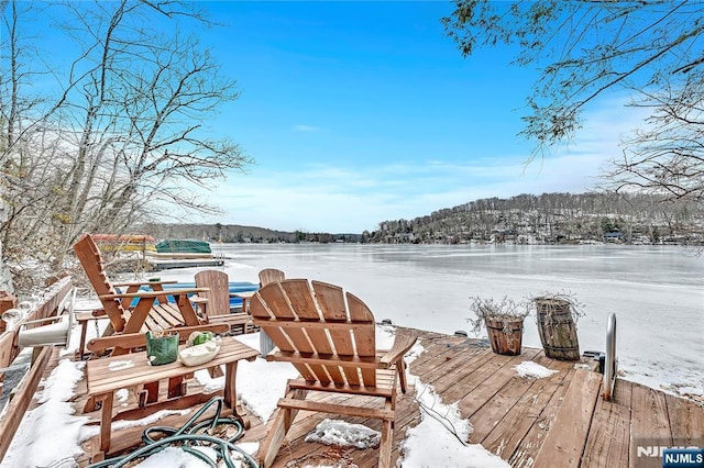 snow covered deck featuring a water view