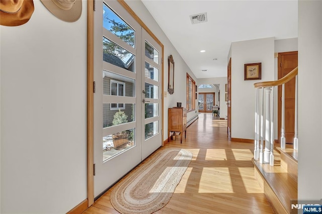 doorway to outside with french doors, visible vents, stairway, light wood-style floors, and baseboards