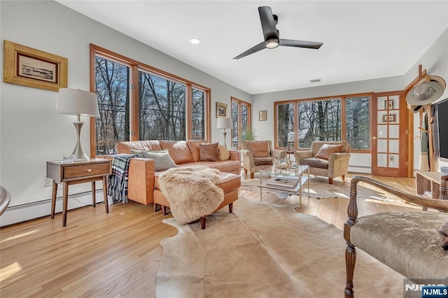 living room with recessed lighting, light wood-style flooring, baseboard heating, a baseboard heating unit, and ceiling fan