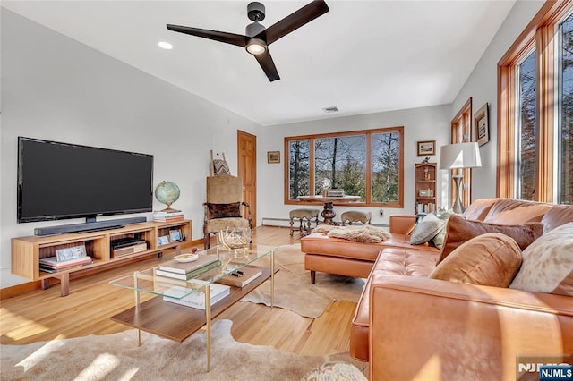 living room featuring baseboards, light wood-style flooring, and a ceiling fan