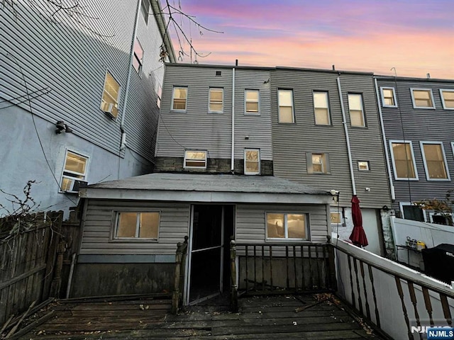 back of property at dusk featuring a fenced backyard