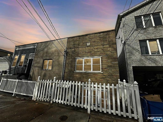 exterior space featuring a fenced front yard and stone siding