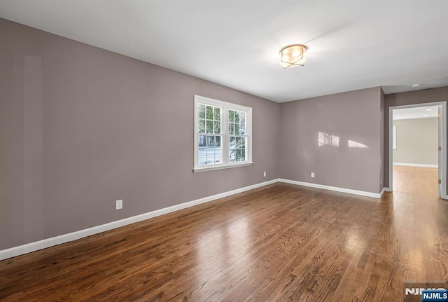 unfurnished room featuring wood finished floors and baseboards