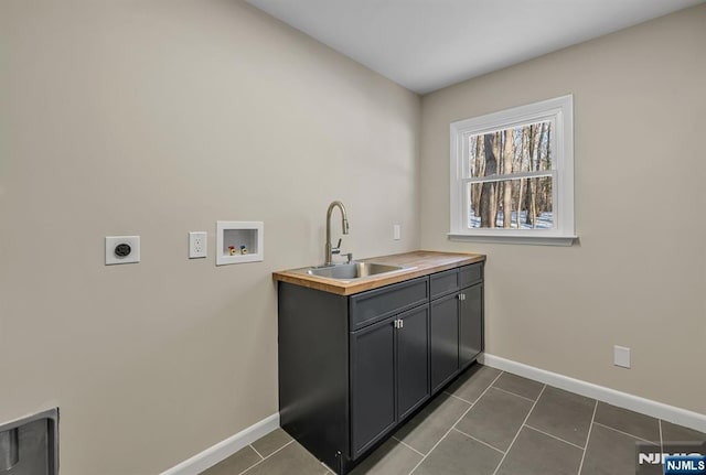 laundry room featuring baseboards, dark tile patterned flooring, hookup for an electric dryer, washer hookup, and a sink