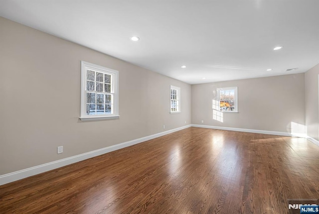 unfurnished room featuring baseboards, wood finished floors, and recessed lighting