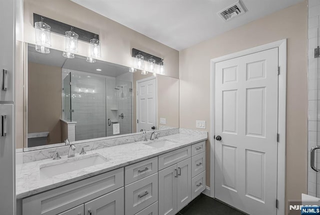 bathroom featuring a stall shower, visible vents, and a sink