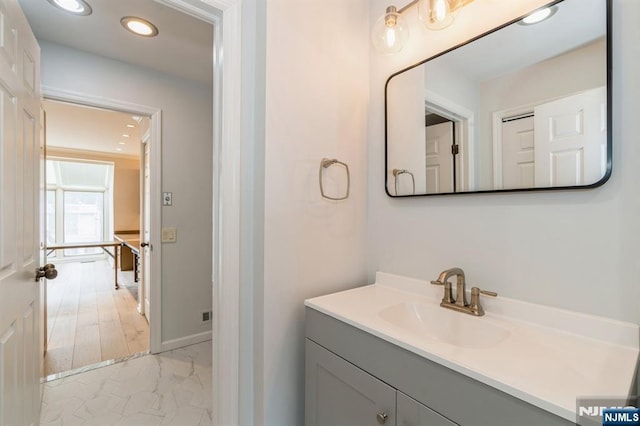 bathroom featuring recessed lighting, marble finish floor, vanity, and baseboards