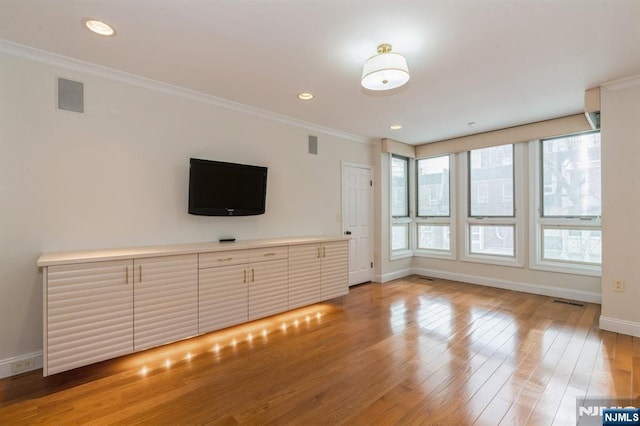 unfurnished living room featuring recessed lighting, visible vents, ornamental molding, light wood-type flooring, and baseboards