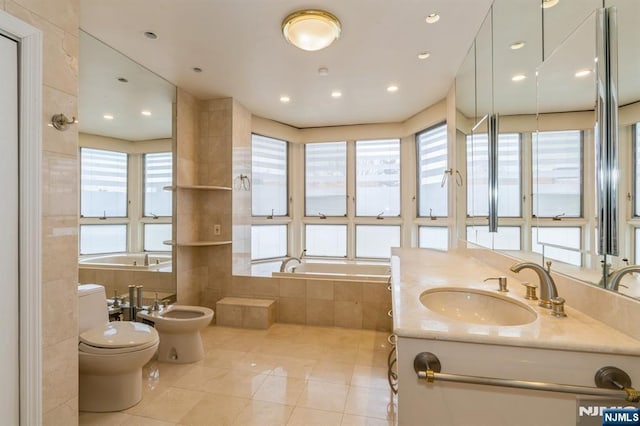 bathroom featuring a garden tub, toilet, a bidet, vanity, and tile patterned floors