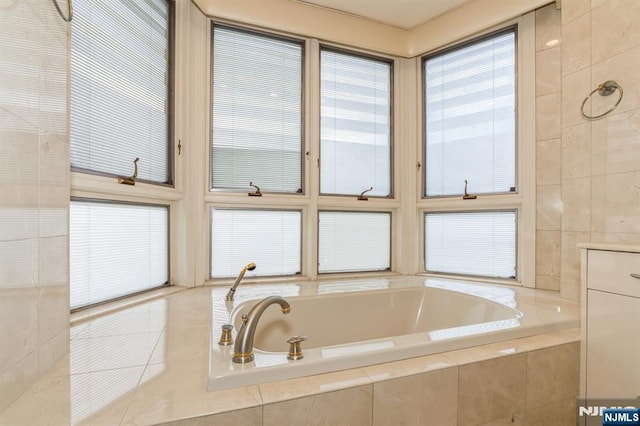 full bathroom featuring tile patterned flooring, tiled bath, and tile walls