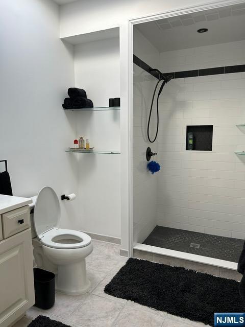 bathroom featuring toilet, a stall shower, and vanity