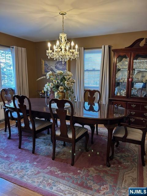 dining area with wood finished floors and a notable chandelier