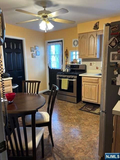 kitchen with ceiling fan, baseboards, stainless steel appliances, and light countertops