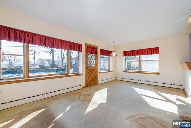 empty room featuring a baseboard heating unit and carpet