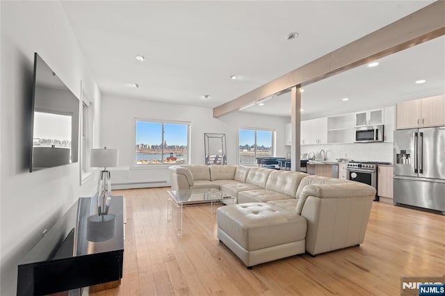 living area with light wood-type flooring, baseboard heating, and recessed lighting