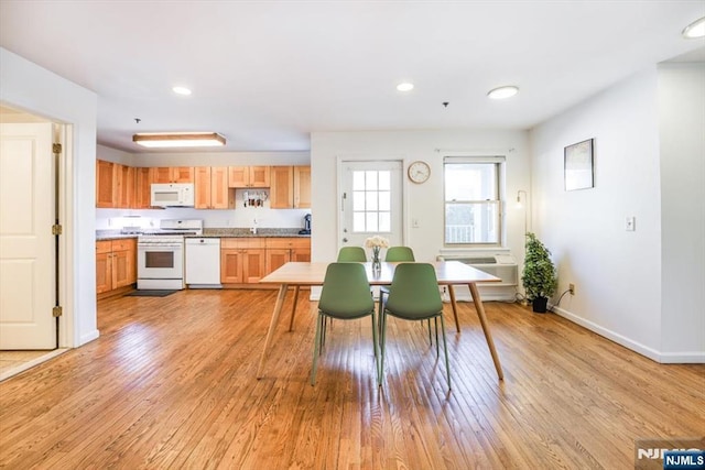 unfurnished dining area with recessed lighting, baseboards, and light wood-style flooring