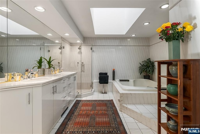 full bathroom with tile patterned flooring, a skylight, a sink, a bath, and a stall shower