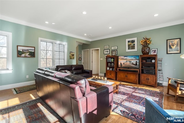 living area with plenty of natural light, crown molding, and wood finished floors