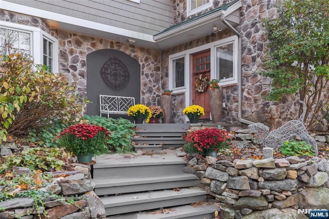 property entrance featuring stone siding