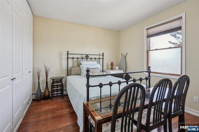 bedroom with dark wood-style flooring, a closet, and baseboards