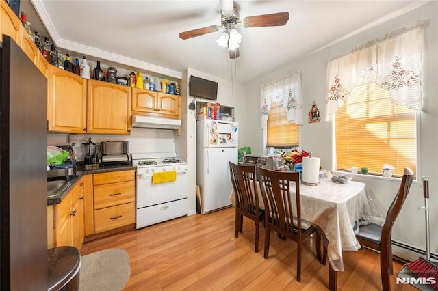 kitchen with white appliances, light wood finished floors, dark countertops, under cabinet range hood, and backsplash