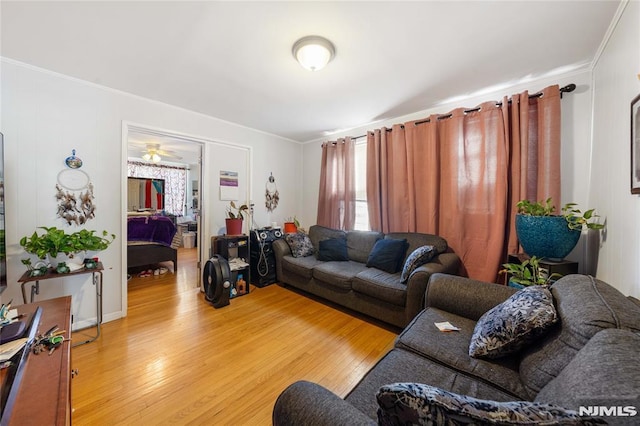 living room with ornamental molding and light wood-style flooring