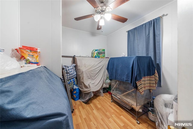 bedroom with crown molding, ceiling fan, and wood finished floors