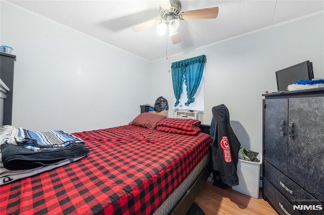 bedroom with ceiling fan, ornamental molding, and wood finished floors