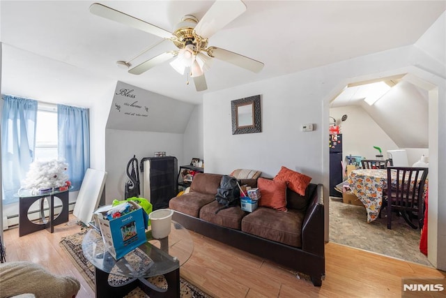 living room with a baseboard radiator, vaulted ceiling, light wood-style flooring, and ceiling fan