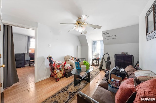 living room featuring light wood finished floors, ceiling fan, and baseboards