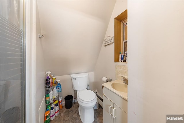 bathroom featuring toilet, lofted ceiling, and vanity