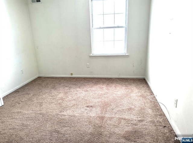 carpeted empty room with visible vents and baseboards