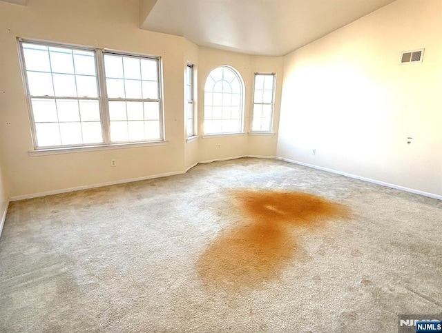 empty room featuring baseboards, visible vents, and carpet flooring