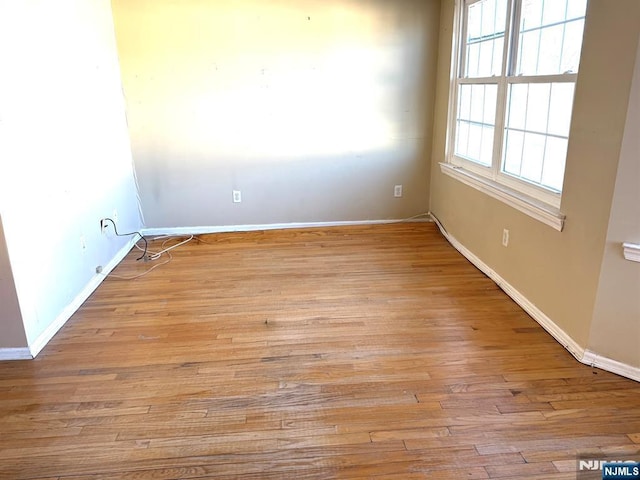 empty room with light wood-style flooring and baseboards