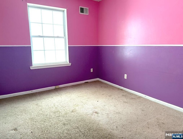 empty room featuring carpet, visible vents, and baseboards