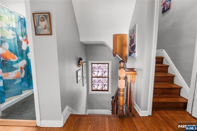 staircase featuring baseboards and wood finished floors