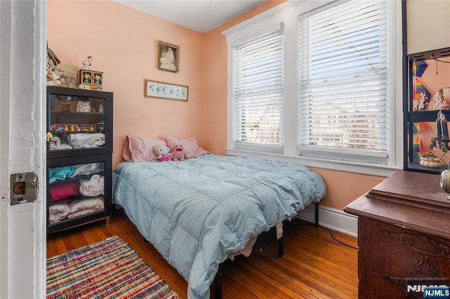 bedroom with dark wood-type flooring and baseboards