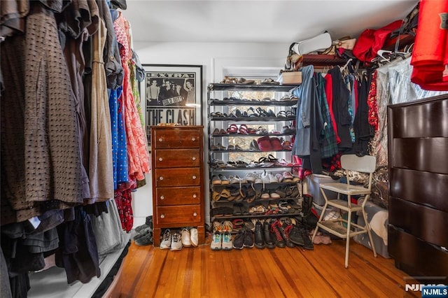 walk in closet with wood finished floors