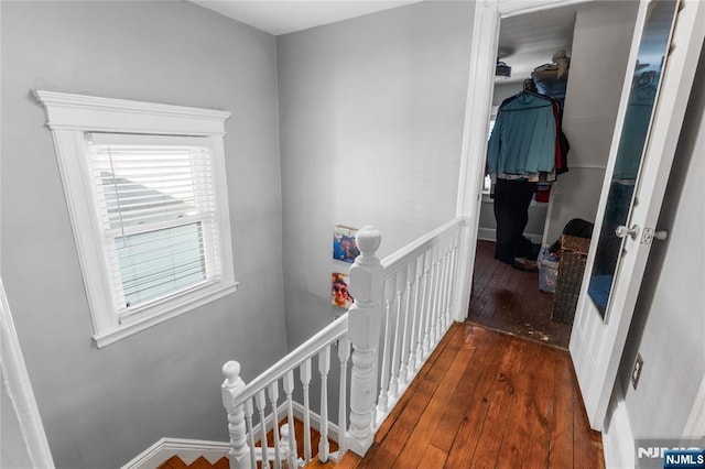 hallway featuring dark wood-style floors and an upstairs landing