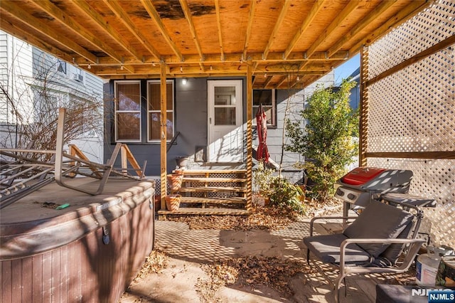 view of patio / terrace featuring entry steps, area for grilling, and a hot tub