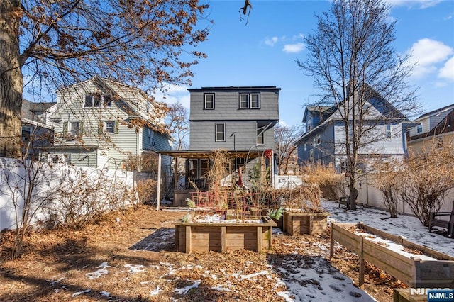 snow covered rear of property with a garden