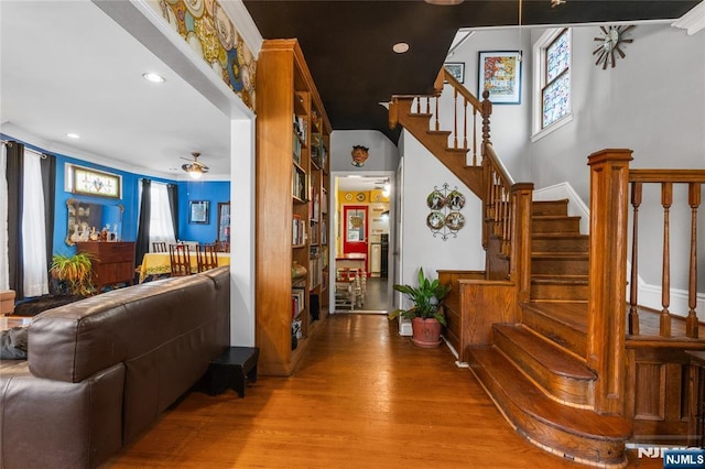 stairway with a ceiling fan, recessed lighting, and wood finished floors