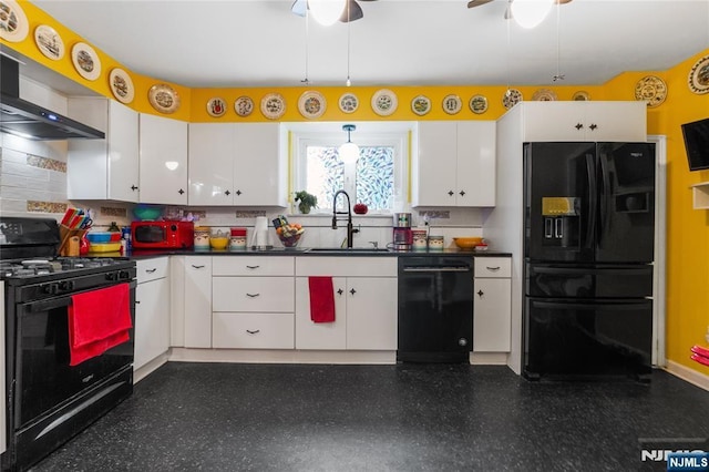 kitchen with dark countertops, black appliances, white cabinets, and a sink