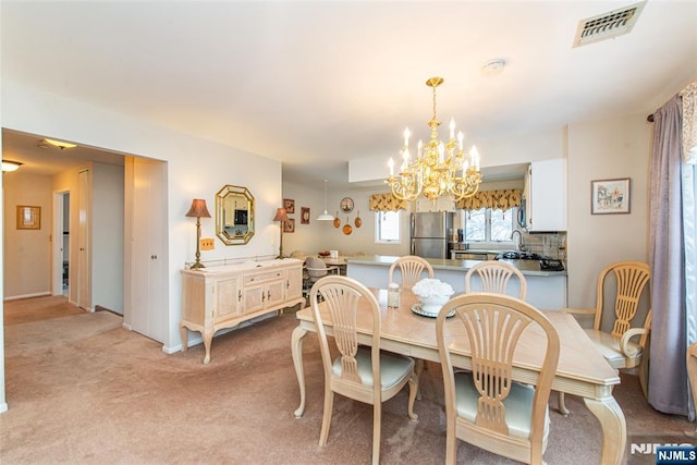 dining room with visible vents, a notable chandelier, and light colored carpet