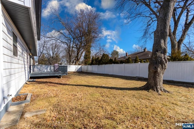 view of yard with a fenced backyard and a wooden deck