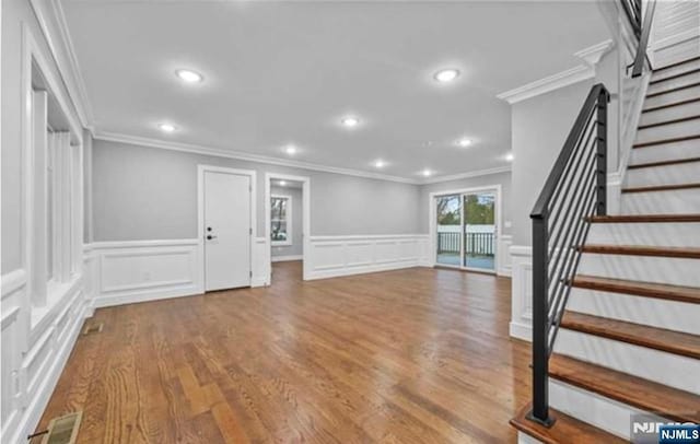 interior space featuring recessed lighting, wood finished floors, visible vents, stairs, and crown molding