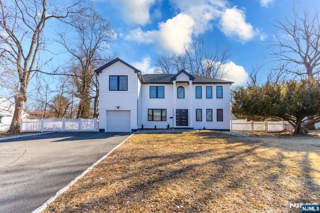 view of front of property with board and batten siding, fence, driveway, and an attached garage