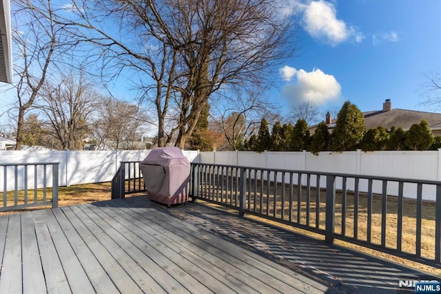 wooden terrace featuring a fenced backyard and a yard